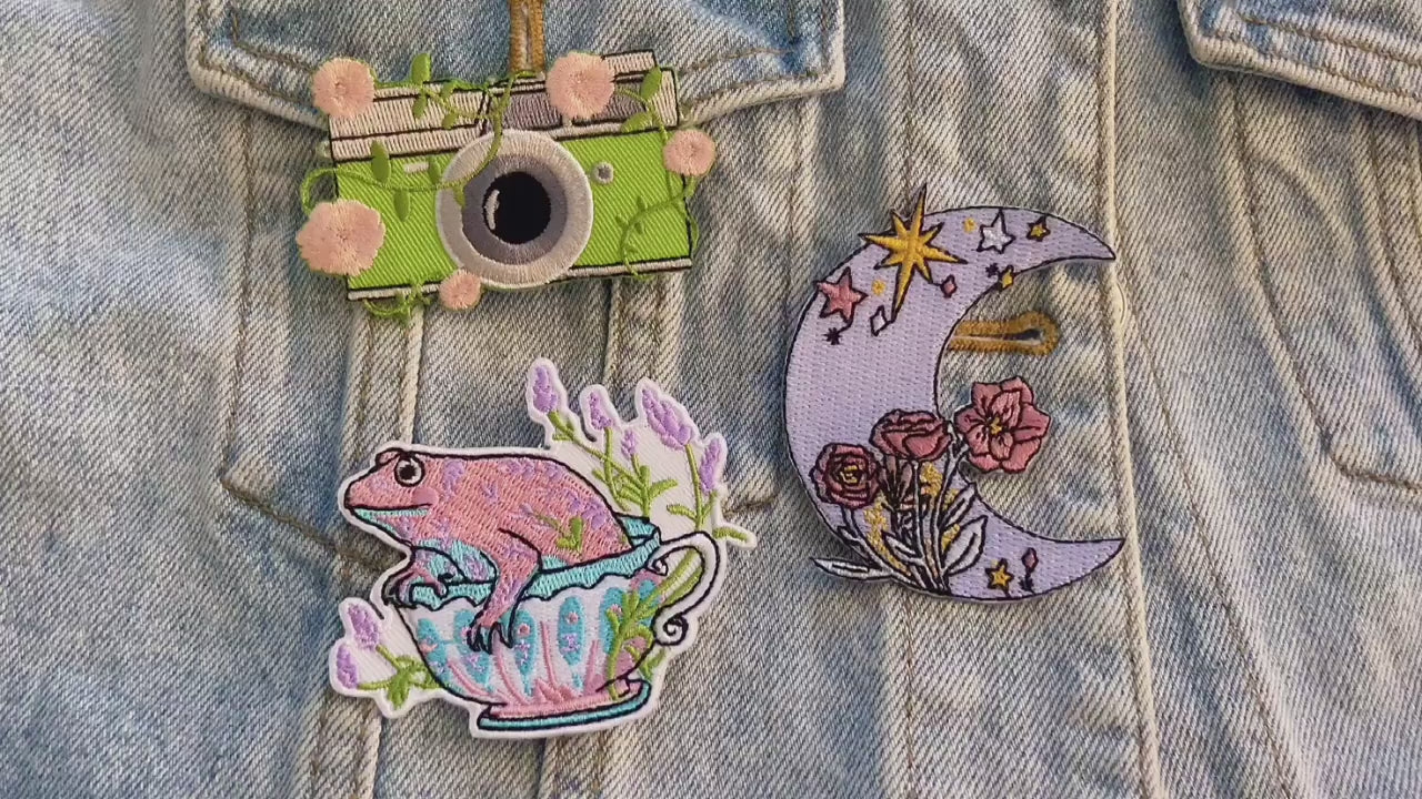 video of a Collection of colorful embroidered patches with various designs on a denim background.