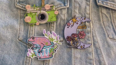 video of a Collection of colorful embroidered patches with various designs on a denim background.