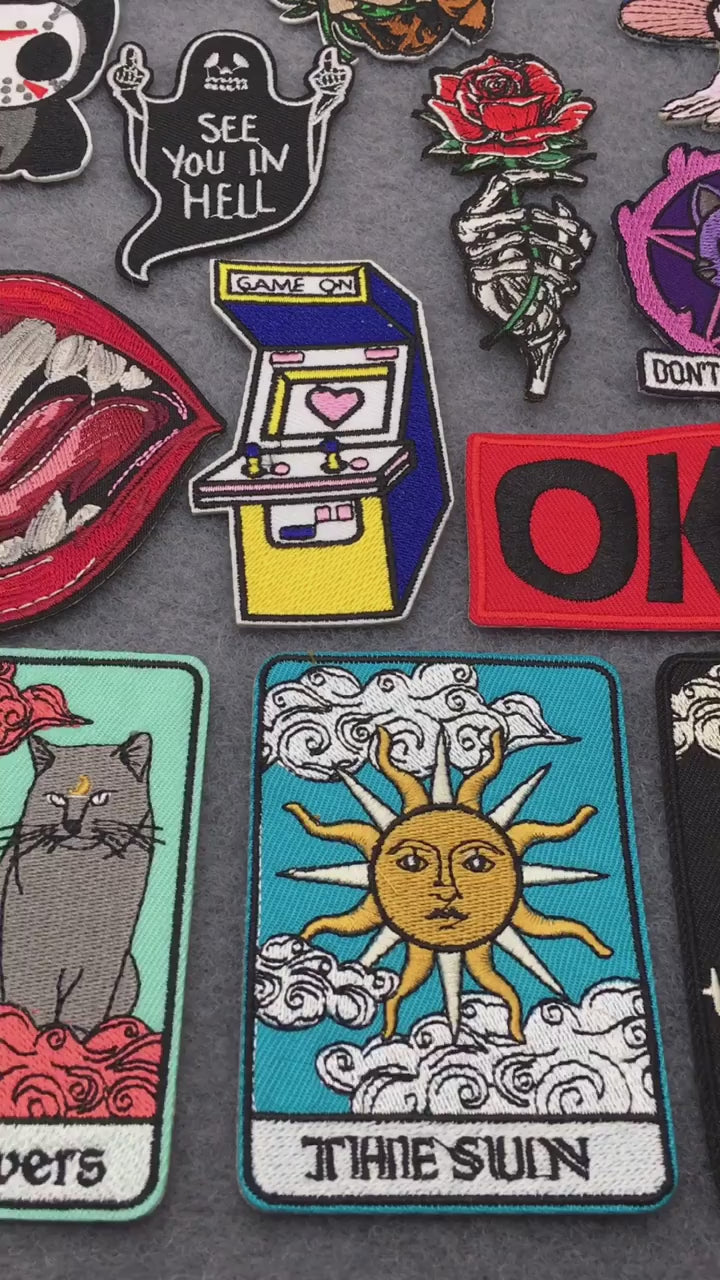 video of Iron-on horror, tarot, gamer, and punk embroidered patches – colorful edgy designs on grey background