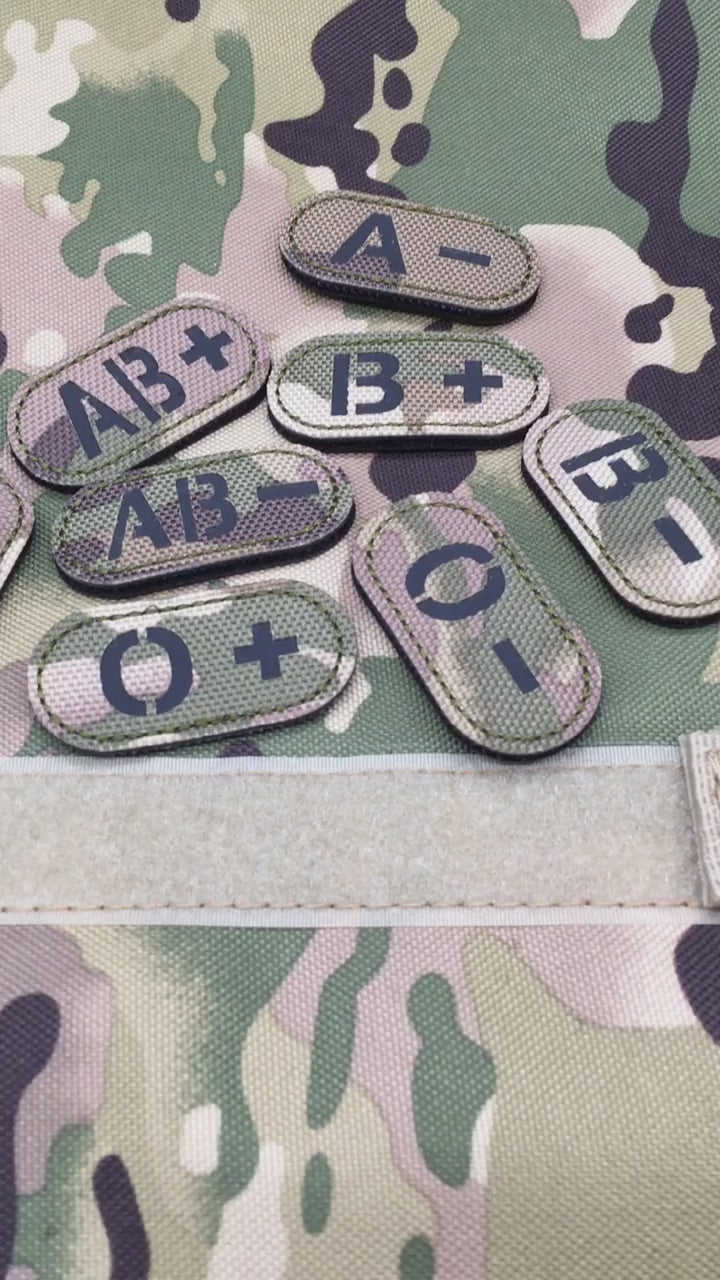 VIDEO OF Set of multicam tactical blood type hook and loop patches with black lettering on a camouflage background