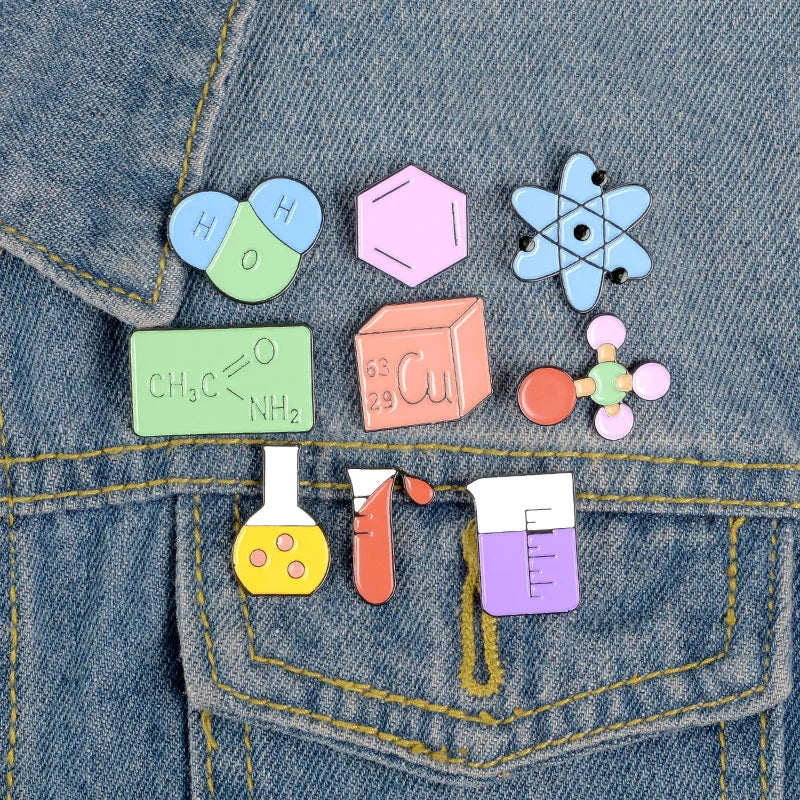 Colorful science-themed pins on a denim background
