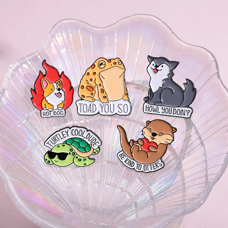 Set of six animal-themed pins on a shell-shaped stand with a pink background