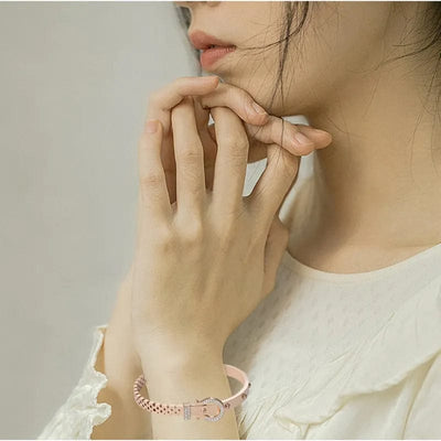 BROOCHITON Bracelets a woman wearing on her left wrist a rose gold bracelet