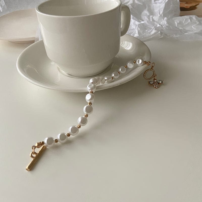 Open pearl bracelet on a coffee cup