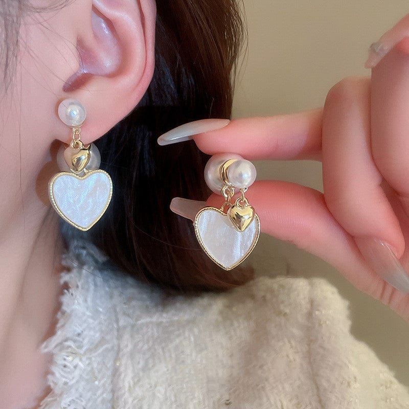 a woman wearing and showing Brushed Love Pearl Earrings