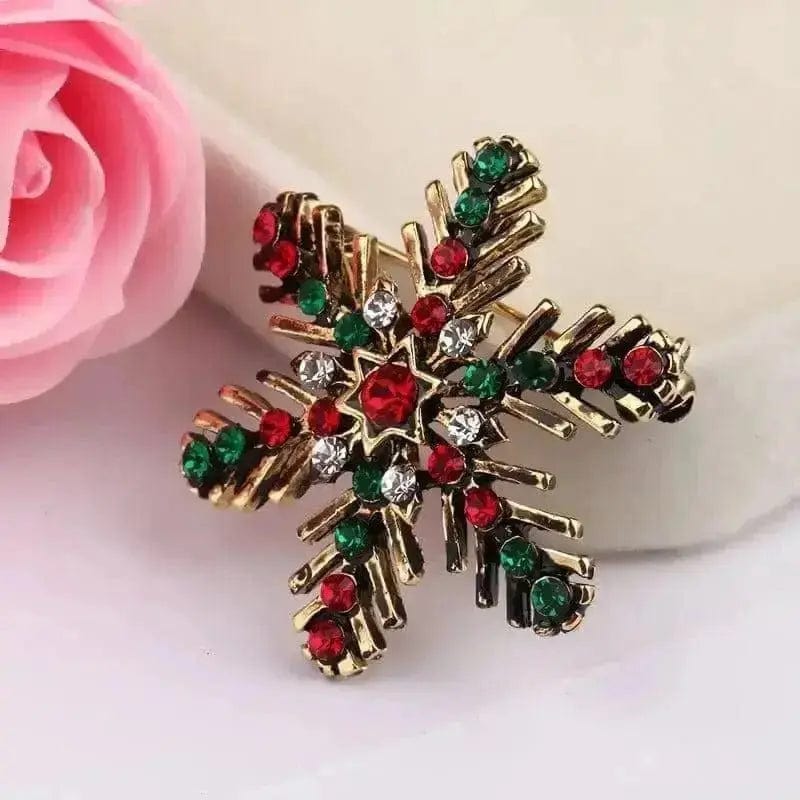 BROOCHITON Brooches Gold Christmas Snowflake Brooch near a pink rose