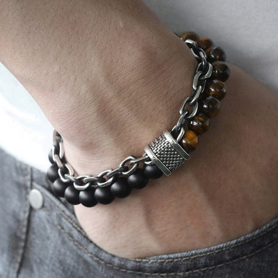 a man hand in jeans pocket wearing a double band bracelet black beads