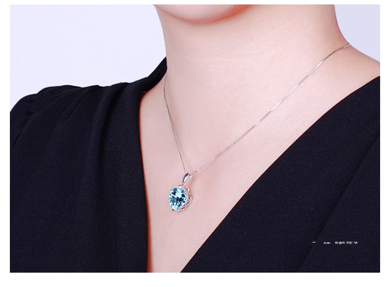 a woman with black dress wearing a topaz pendant ocean heart necklace